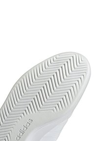 White rubber sneaker sole featuring a herringbone pattern, with textured detailing and the brand name "Adidas" embossed on the side.