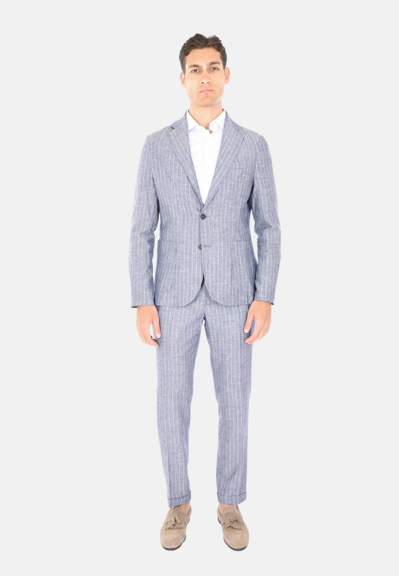 Abito a righe sottili azzurro chiaro realizzato in tessuto texture, con giacca a un bottone e pantaloni affusolati, abbinato a una camicia bianca.
