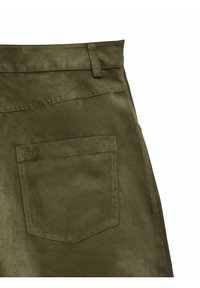 Jupe en tissu suède vert olive avec une poche appliquée à l'arrière et un détail de passant de ceinture sur fond blanc.