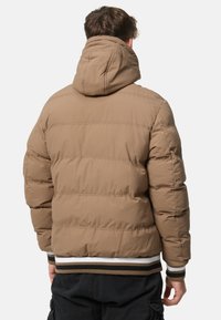 Brown padded jacket featuring a hood, ribbed cuffs with striped accents, and a quilted design on the back for insulation.
