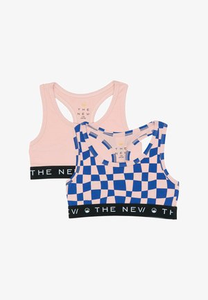 Twee sportbeha's voor kinderen met racerback-ontwerpen; de ene effen lichtroze, de andere met een roze en blauw geruit patroon, beide met zwarte elastische banden met het opschrift "THE NEW."