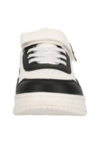 Sneaker noir et blanc avec un upper en cuir lisse, des lacets élastiques, une sangle velcro et une semelle en caoutchouc texturé.