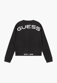 Sudadera corta negra con un logo blanco de "GUESS" en la parte posterior y el texto "EST. 1981" en el dobladillo. Fabricada con un material suave y con puños acanalados.