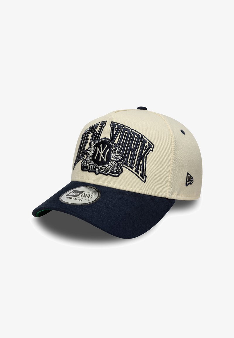 Casquette de baseball avec couronne beige et visière bleu marine, brodée de "NEW YORK" et d'un emblème NY à l'avant, sangle réglable visible à l'intérieur de la visière.