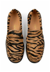 Brown and black tiger stripe loafers made of soft fur with rounded toe and slip-on design. Notable stitching detail and black outsole.