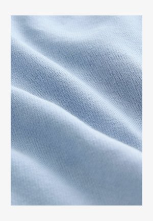 Lyseblå stof med en glat, blød tekstur og et subtilt strikket mønster, der viser bløde folder og rynker.