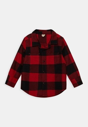 Chemise à manches longues rouge et noire à carreaux avec col et deux poches poitrine, posée à plat sur fond blanc.