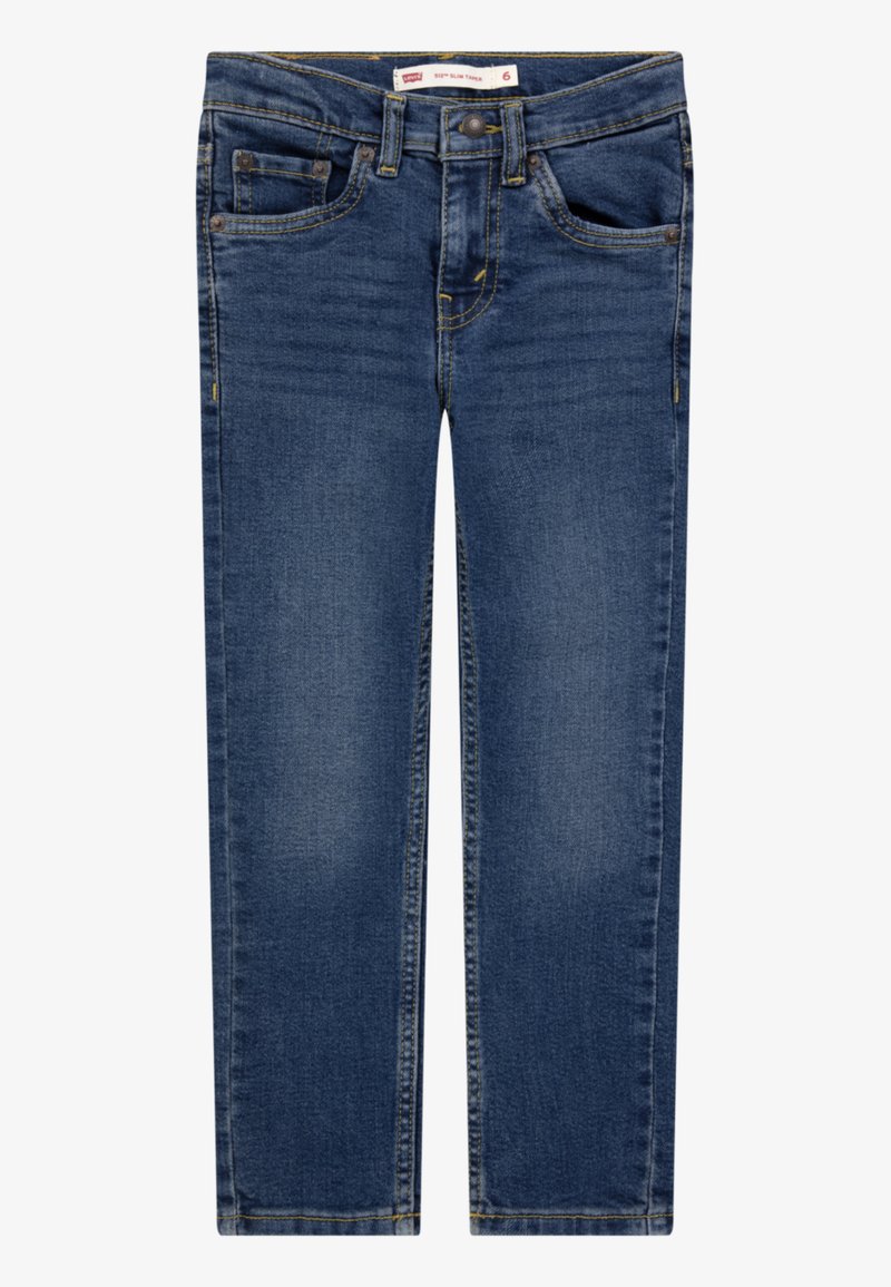 Tummansiniset farkut kapealla istuvuudella. Omaleimaiset viisi taskua, keltaiset saumat sekä vetoketjullinen ja nappikiinnitteinen edusta.