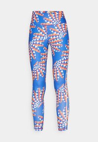 Kompressiohousut kirkkaan sinisellä värillä, joissa on geometrinen kuvio punaisista ja valkoisista muodoista. Suunniteltu korkealla vyötäröllä ja saumanvaratonna.