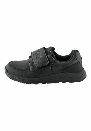 Schwarzer flacher Schuh mit gepolstertem Schaft, dicker Sohle und breitem Klettverschluss oben für einfaches An- und Verstellen.