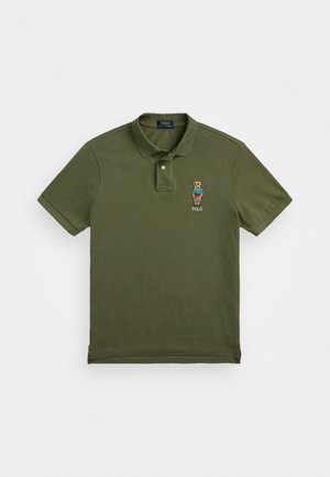 Olive green polo shirt made of cotton, featuring a classic collar, two buttons, and a small embroidered bear logo on the left chest.