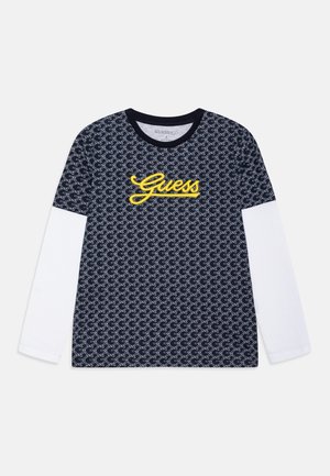 Koszulka z długim rękawem z granatowym wzorzystym korpusem, białymi rękawami oraz żółtym logo "Guess" z przodu. Materiał z mieszanki bawełny.