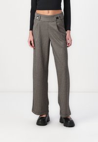 Kalhoty s vysokým pasem a širokými nohavicemi ve vzoru houndstooth v černé a béžové barvě, s dvěma předními kapsami a výraznými detaily knoflíků.