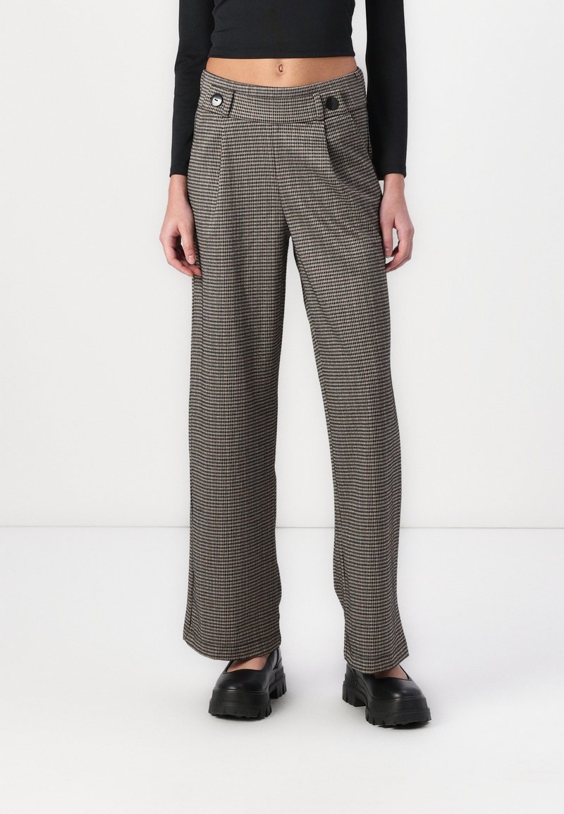 Kalhoty s vysokým pasem a širokými nohavicemi ve vzoru houndstooth v černé a béžové barvě, s dvěma předními kapsami a výraznými detaily knoflíků.