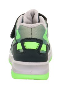 Tenisky s černou a zelenou síťovinou na svršku, polstrovaným šedým límcem a zelenou gumovou podrážkou. Umožňují zapínání na jeden suchý zip.