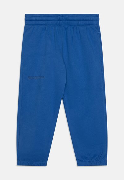 Pantalones de chándal azules hechos de una tela suave, con una cintura elástica, piernas ajustadas y un detalle impreso en la pierna izquierda.