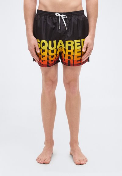 Shorts de bain noirs avec texte dégradé du jaune au rouge indiquant "SQUARED." Dotés d'une taille élastique avec cordon de serrage et d'une finition lisse.