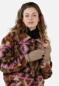 Giacca di lana multicolore con motivi geometrici in marrone, rosa e grigio, dotata di grandi bottoni e guanti senza dita coordinati.