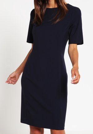 Marineblaues, kurzärmeliges Kleid mit figurbetonter Silhouette aus glattem Stoff. Knielanges Design mit dezenten Nahtdetails über das ganze Kleid.