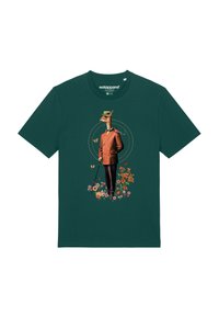 T-shirt à manches courtes teal avec un motif de girafe en costume marron, entouré de fleurs colorées et de papillons.