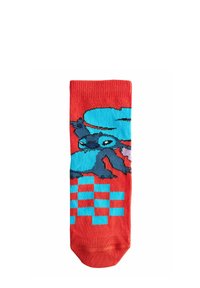 Punaiset sukat, joissa on sininen mustekalakuosi, ja pohjassa ruudullinen kuvio. Valmistettu neulotuista kankaista, yläosassa ribbitekstuuri.