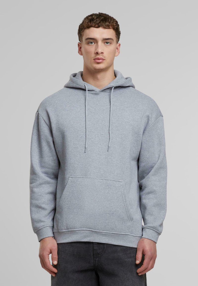 Felpa grigia con cappuccio realizzata in tessuto morbido, dotata di tasca a marsupio, cappuccio con cordino e polsini a costine. Vestibilità classica con design rilassato.