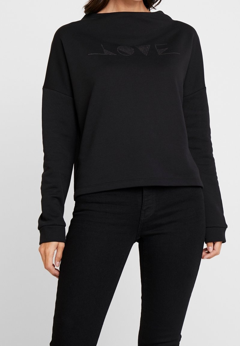 Sweat-shirt noir à coupe décontractée, avec un motif en relief discret "LOVE" sur la poitrine et des manches longues avec des poignets côtelés.