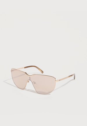 Gafas de sol estilo escudo de gran tamaño con lentes rosa claro y montura delgada de metal dorado, con un recorte en el centro superior.