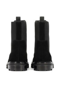 Fekete velúr és bőr bokacipő pár vastag, barázdált talppal és szövet húzófülekkel a hátoldalon.