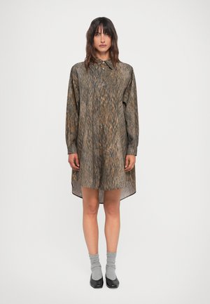 Long-sleeve shirt dress in a textured brown and orange pattern, featuring a button-down front and a curved hem, paired with gray socks and black shoes.