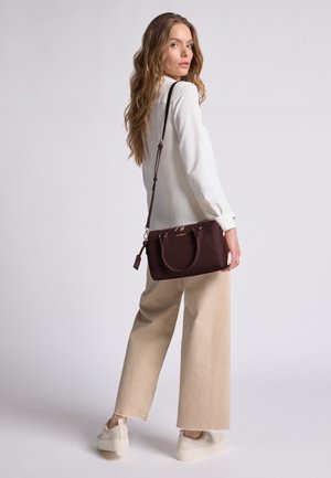 Bolso de mano de cuero marrón con asas dobles y una correa desmontable, con una superficie texturizada y acentos en hardware dorado.