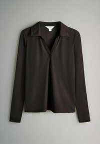 Maglietta nera a maniche lunghe con scollatura a V e colletto. Realizzata in un tessuto morbido, presenta una vestibilità comoda e nessun motivo o hardware visibile.