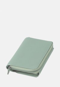 Groene leren portemonnee met een gladde textuur, afgeronde hoeken en een ritsluiting. Kenmerkt zich door contrasterende stiksels langs de randen.