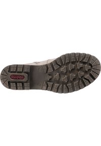 Suela de bota de senderismo de color gris claro con surcos profundos, que presenta goma negra para agarre y un inserto con logo rojo. Materiales duraderos para tracción.