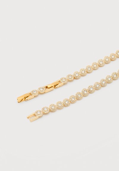 Bracelet en or avec des sertissages circulaires, chacun contenant une pierre précieuse claire centrale entourée de petits cristaux, posé à plat sur une surface blanche.