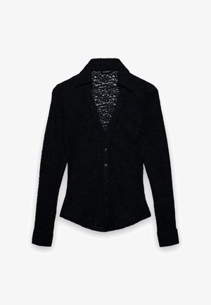 Maglietta nera a maniche lunghe in tessuto strutturato con scollo a V e chiusura con bottoni. Presenta un colletto e un orlo leggermente curvo.