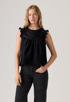 Zwarte mouwloze top met geschulpte randen, geborduurde details en franjes. Losse pasvorm met gathering-styling op de borst.