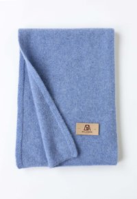 Écharpe en laine bleu clair, texture douce, pliée avec une étiquette en cuir portant "BELLEMERE." Les bords sont cousus pour plus de durabilité.