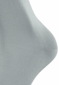 Light gray, ribbed ankle sock made from stretchy fabric, featuring a smooth texture and a close-fitting shape that contours to the foot.