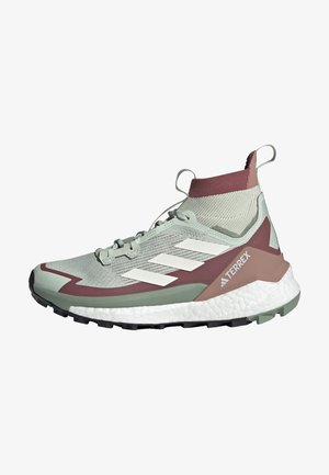 Sport shoe features a light green mesh upper with maroon accents, white stripes, textured collar, and a thick white midsole. Rubber outsole visible.