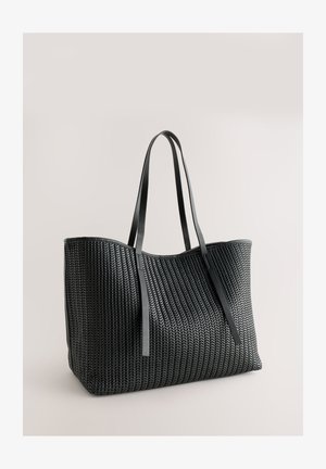 Black woven tote bag with smooth leather accents and sturdy shoulder straps, featuring a spacious rectangular shape and a textured pattern.