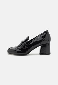 Mocassins à talons en cuir verni noir avec un bout arrondi, dotés d'une sangle à l'avant et d'un talon carré. Fini lisse avec un léger éclat.