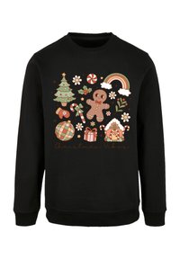 Sudadera negra con un gráfico colorido de temática navideña que incluye un árbol, un hombre de jengibre, caramelos y acentos festivos, etiquetado como "Vibras Navideñas".