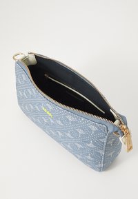 Modrá denimová clutch taška s bílým logem, zlatým zipem a světle barevnou podšívkou. Vyznačuje se jednoduchým, obdélníkovým tvarem.
