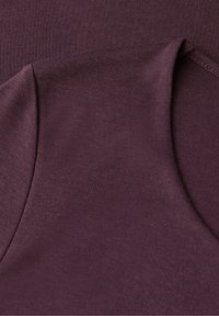 Tmavě burgundová tkanina s hladkou strukturou a jemným pletením, vybavená zaobleným výstřihem a bezešvým lemováním. Měkký a lehký materiál.