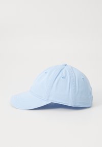 Lyseblå bomull baseballcaps med buet skjerm, seks ventilasjons hull, og en typisk strukturert form. Ingen synlig merking eller mønstre.