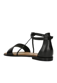 Zwarte leren sandaal met een open teen, gevlochten enkelband en een lage hak. Heeft een gladde textuur en minimale designelementen.