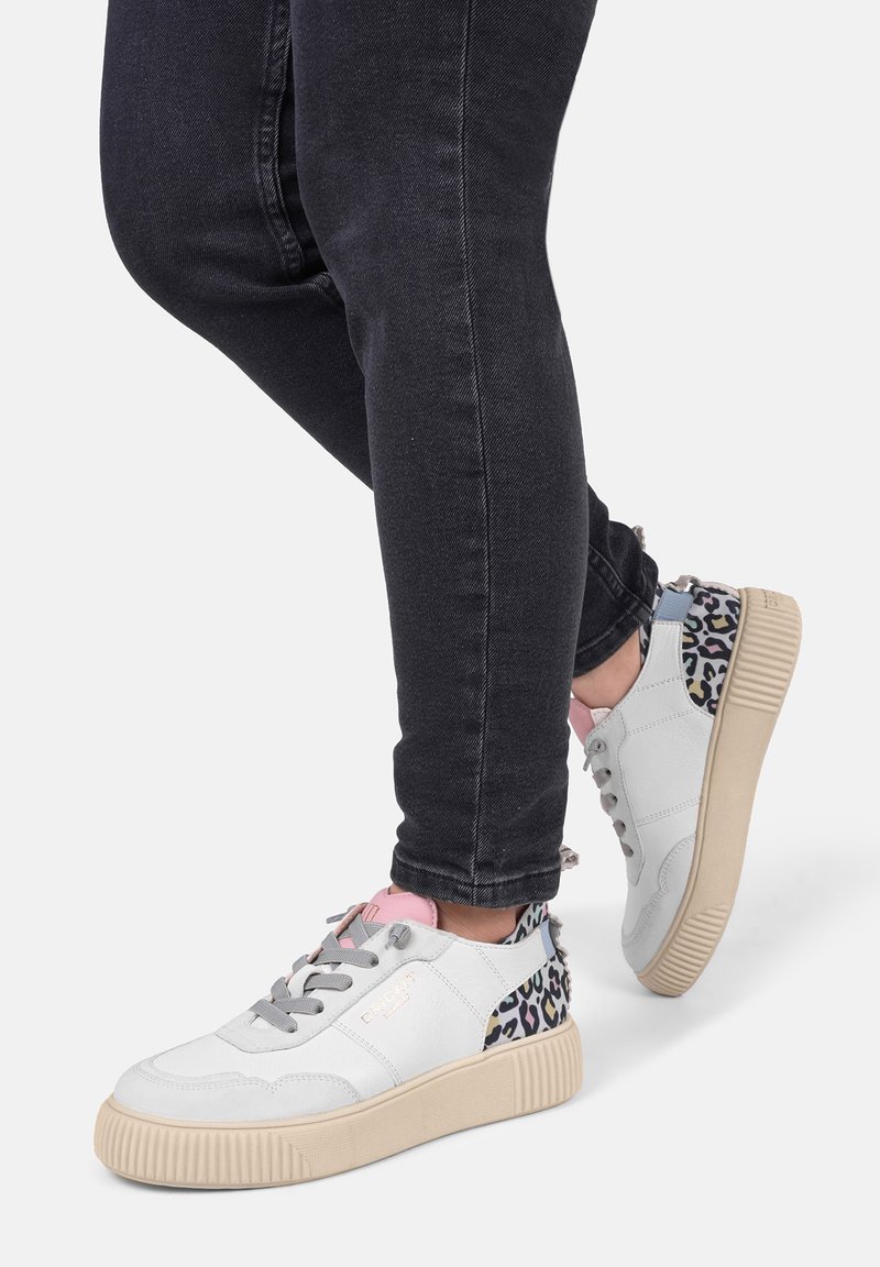 Baskets de sport blanches avec des lacets gris, un accent rose sur la languette et un talon à motif léopard. Semelle texturée avec une bonne adhérence.