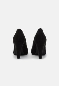 Černé semišové lodičky s kulatou špičkou a zakřiveným siluetou, s blokovým podpatkem střední výšky. Hladká textura a klasický design.