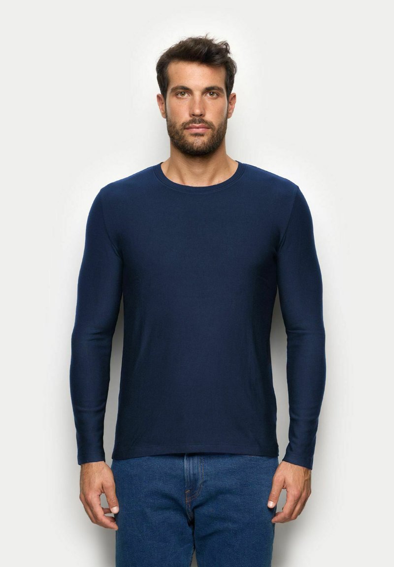 Granatowa koszula z długim rękawem wykonana z gładkiego materiału, z okrągłym dekoltem. Posiada dopasowane rękawy i prosty, minimalistyczny design.